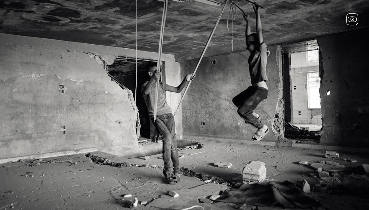Minor scrap pickers playing during a break inside a building destroyed in the civil war in Damascus’s suburb, Syria. 
