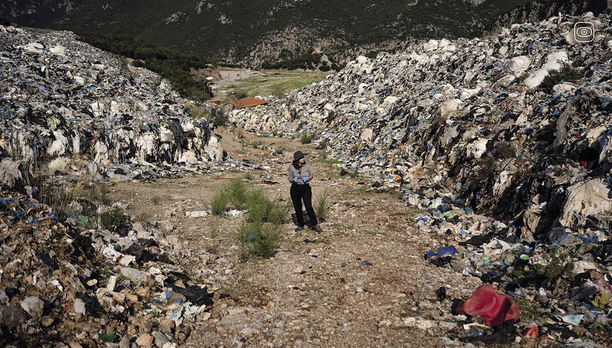 Reporter Eurydice Bersi walks among the piles of waste that remain around the now closed Maratholaka landfill in Greece's southern Peloponnese.