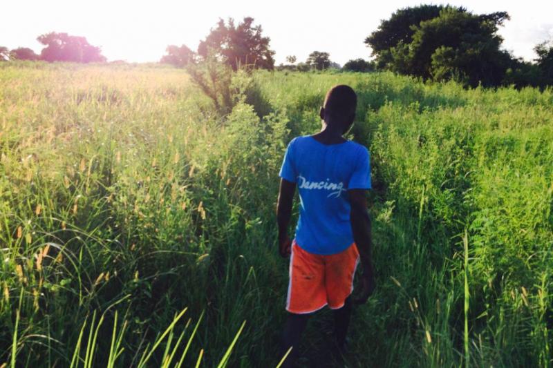 Albert Adongo (15) shows us around a piece of wasteland where tomatoes used to be grown.