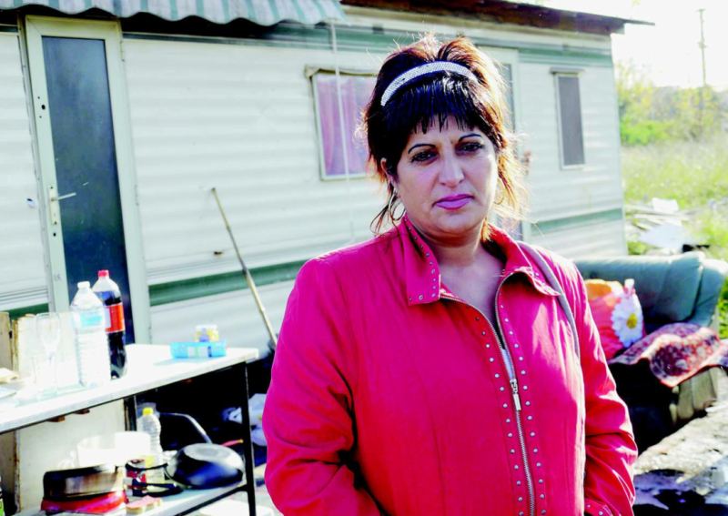 A woman from the Roma community in front of her caravan.