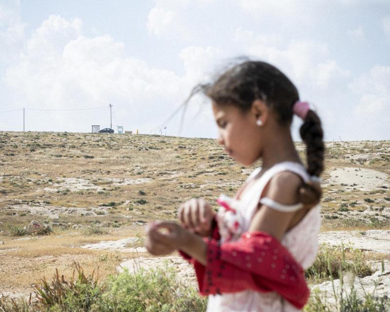 Het zesjarige meisje dat woont in een van de dorpen van Masafer Yatta staat voor de heuvel die leidt naar een Israelische outpost. 
