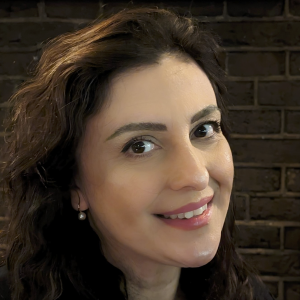 a smiling young woman with dark hair, 3/4 portrait